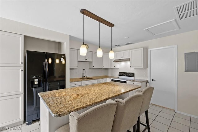 4969 Vincennes St, Cape Coral, FL 33904 - kitchen featuring black fridge with ice dispenser, white range with electric stovetop, a sink, under cabinet range hood, and a breakfast bar
