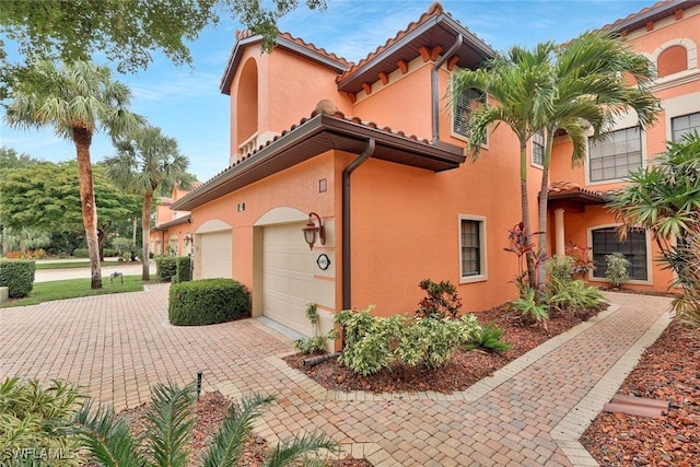 5795 Grande Reserve Way Unit 1001, Naples, FL 34110 - view of side of home with stucco siding, a tiled roof, and driveway