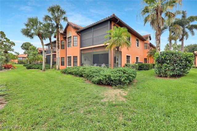 5795 Grande Reserve Way Unit 1001, Naples, FL 34110 - back of house with stucco siding and a lawn