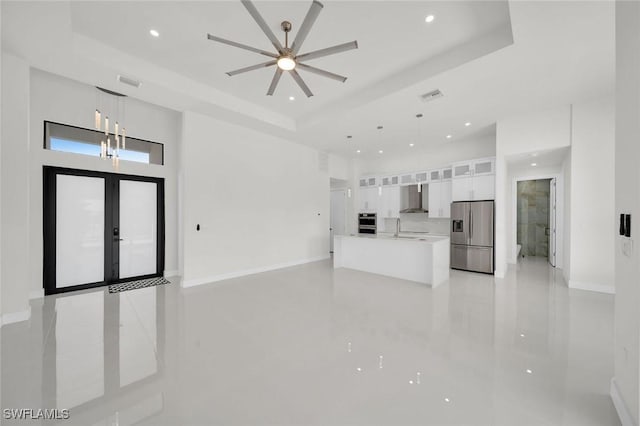 2219 Surfside Blvd, Cape Coral, FL 33991 - unfurnished living room with a tray ceiling, recessed lighting, baseboards, a high ceiling, and a chandelier
