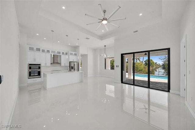 2219 Surfside Blvd, Cape Coral, FL 33991 - unfurnished living room with a tray ceiling, recessed lighting, a towering ceiling, ceiling fan, and baseboards