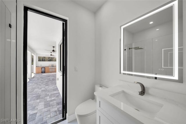 2219 Surfside Blvd, Cape Coral, FL 33991 - bathroom with toilet, vanity, brick patterned flooring, ceiling fan, and a shower