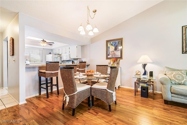 6324 Sugar Bush Ln Unit F, Fort Myers, FL 33908 - dining space featuring light wood finished floors, baseboards, a chandelier, ceiling fan, and vaulted ceiling