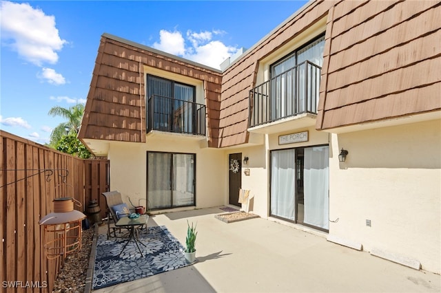 5210 Cedarbend Dr Unit 4, Fort Myers, FL 33919 - rear view of property featuring stucco siding, mansard roof, a patio area, and a balcony