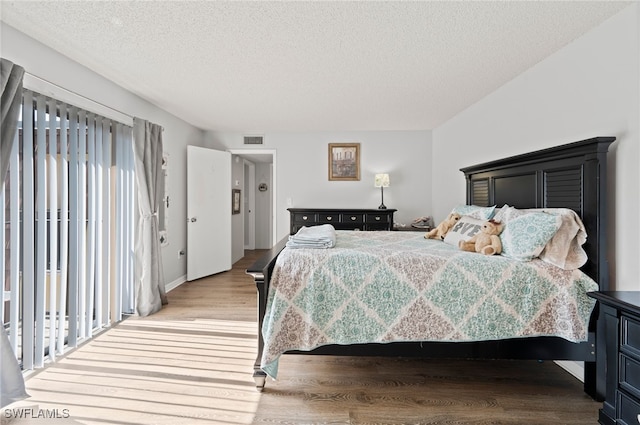 5210 Cedarbend Dr Unit 4, Fort Myers, FL 33919 - bedroom featuring light wood-style floors, multiple windows, and a textured ceiling