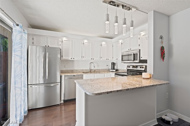 5210 Cedarbend Dr Unit 4, Fort Myers, FL 33919 - kitchen featuring appliances with stainless steel finishes, a sink, a textured ceiling, white cabinetry, and a peninsula