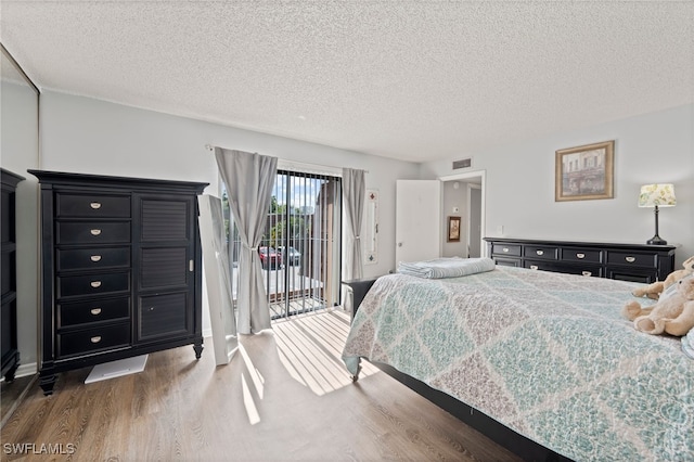 5210 Cedarbend Dr Unit 4, Fort Myers, FL 33919 - bedroom featuring wood finished floors, access to outside, and a textured ceiling