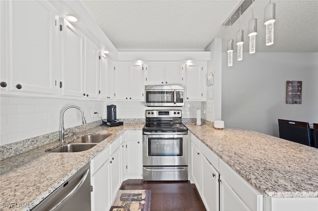 5210 Cedarbend Dr Unit 4, Fort Myers, FL 33919 - kitchen with appliances with stainless steel finishes, a sink, a textured ceiling, a peninsula, and white cabinetry