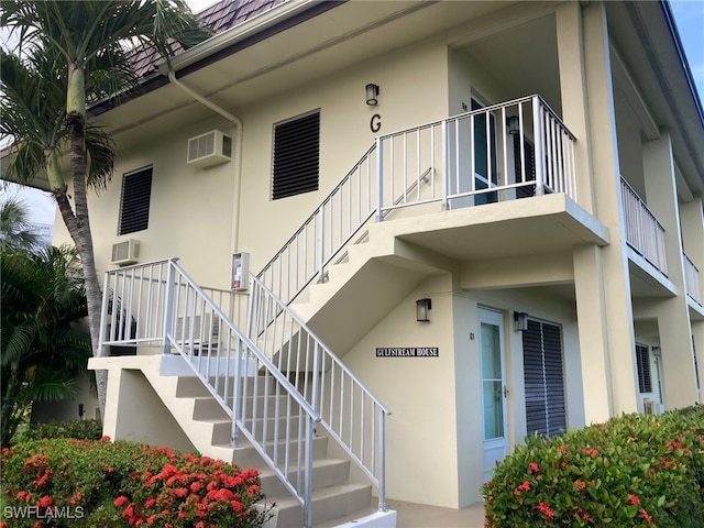 130 N Collier Blvd Unit G6, Marco Island, FL 34145 - view of exterior entry featuring stucco siding and a wall mounted AC