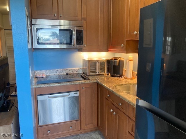 130 N Collier Blvd Unit G6, Marco Island, FL 34145 - kitchen with refrigerator, stainless steel microwave, black electric stovetop, wall oven, and light stone countertops