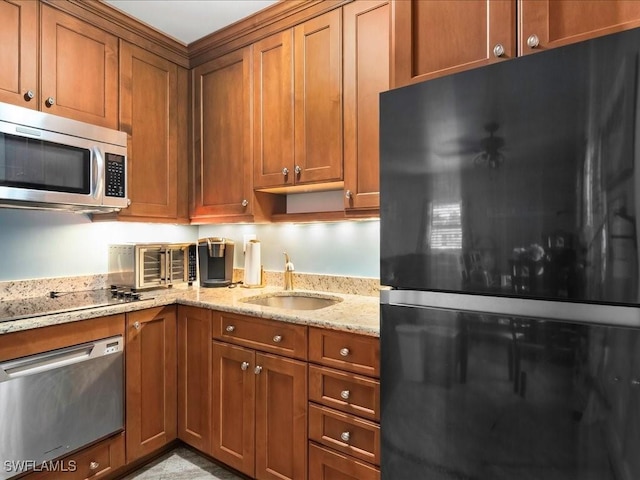 130 N Collier Blvd Unit G6, Marco Island, FL 34145 - kitchen featuring black appliances, brown cabinets, and light stone counters