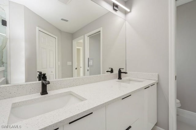 1603 Karen Ave S, Lehigh Acres, FL 33976 - bathroom with double vanity, toilet, and baseboards