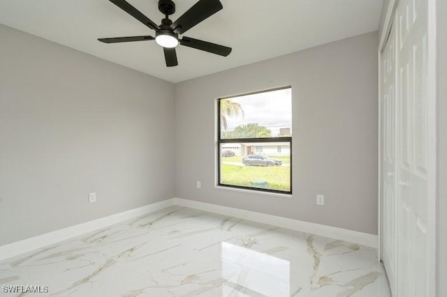 1603 Karen Ave S, Lehigh Acres, FL 33976 - unfurnished room with baseboards, a ceiling fan, and marble finish floors