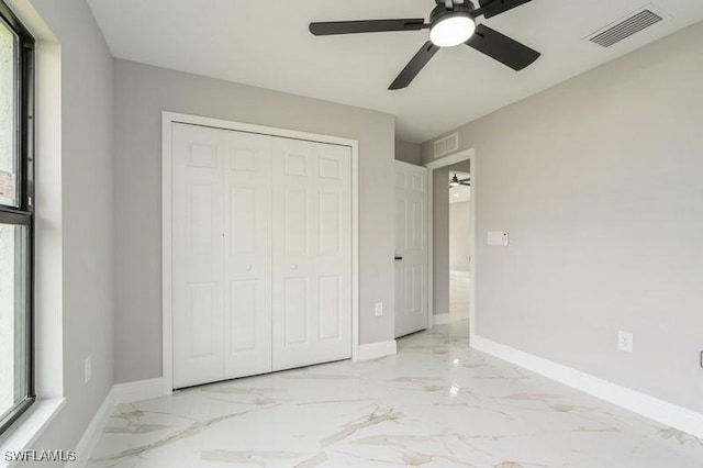 1603 Karen Ave S, Lehigh Acres, FL 33976 - unfurnished bedroom with multiple windows, marble tiled floors, a closet, and baseboards