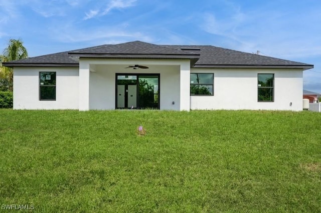 1603 Karen Ave S, Lehigh Acres, FL 33976 - back of property featuring a yard, stucco siding, roof with shingles, and ceiling fan