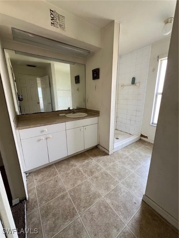 3513 30th St SW, Lehigh Acres, FL 33976 - bathroom with vanity, a stall shower, tile patterned floors, and baseboards