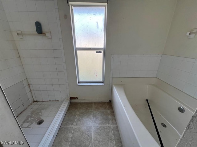 3513 30th St SW, Lehigh Acres, FL 33976 - full bathroom featuring a garden tub, tile patterned flooring, and a tile shower