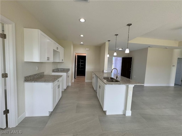 3007 53rd St W, Lehigh Acres, FL 33971 - kitchen with a sink, light stone countertops, baseboards, white cabinetry, and recessed lighting