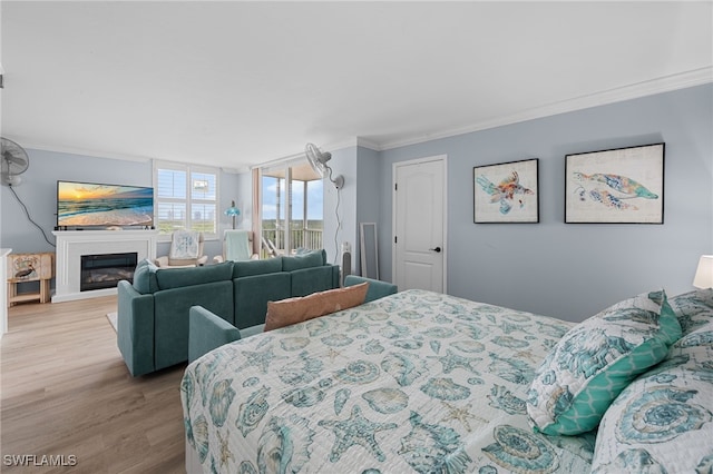 5500 Bonita Beach Rd Unit 502, Bonita Springs, FL 34134 - bedroom with crown molding, wood finished floors, and a glass covered fireplace