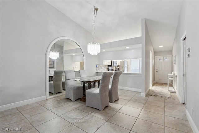 3410 Frosty Way Unit 4802, Naples, FL 34112 - dining area featuring a chandelier, light tile patterned floors, baseboards, lofted ceiling, and arched walkways