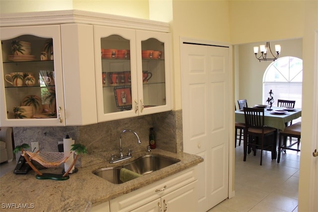 672 Seagrape Dr, Marco Island, FL 34145 - kitchen featuring a sink, a chandelier, light stone counters, and decorative backsplash