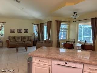 672 Seagrape Dr, Marco Island, FL 34145 - kitchen with open floor plan, dishwashing machine, light tile patterned floors, and light stone countertops