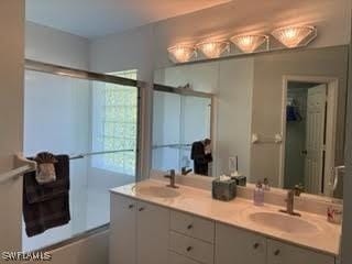 672 Seagrape Dr, Marco Island, FL 34145 - bathroom featuring double vanity and a shower with shower door