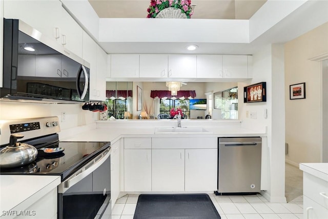 7340 Coventry Ct Unit 827, Naples, FL 34104 - kitchen with stainless steel appliances, light countertops, white cabinets, and light tile patterned flooring