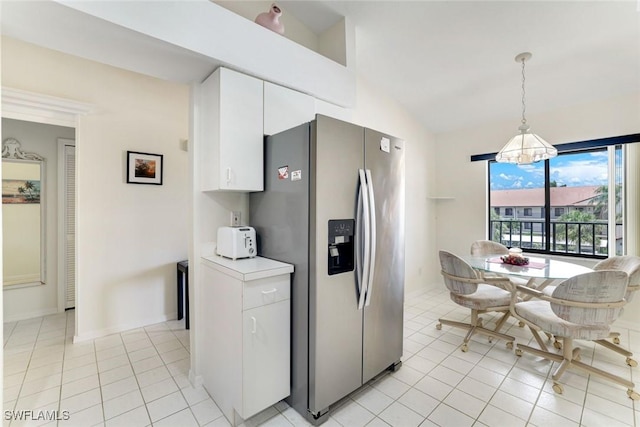 7340 Coventry Ct Unit 827, Naples, FL 34104 - kitchen with stainless steel fridge, lofted ceiling, white cabinetry, light countertops, and light tile patterned floors