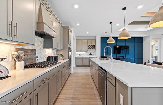 7393 Blue Salvia Dr, North Fort Myers, FL 33917 - kitchen with gray cabinets, premium range hood, stainless steel appliances, a sink, and backsplash