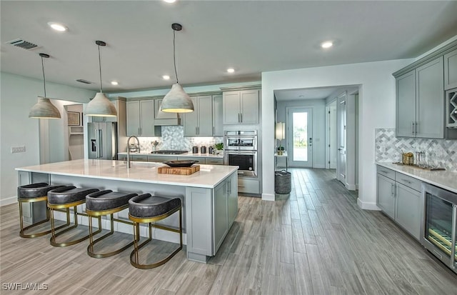 7393 Blue Salvia Dr, North Fort Myers, FL 33917 - kitchen featuring a sink, stainless steel appliances, gray cabinetry, decorative backsplash, and recessed lighting