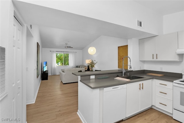 8224 Key Royal Cir Unit 232, Naples, FL 34119 - kitchen featuring white appliances, a sink, a peninsula, dark countertops, and vaulted ceiling