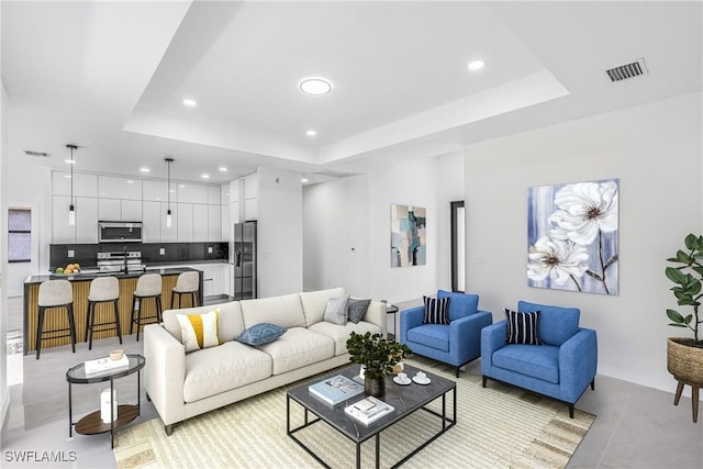 living room with recessed lighting, a raised ceiling, light tile patterned floors, and baseboards