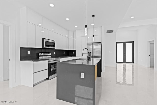 kitchen featuring appliances with stainless steel finishes, modern cabinets, a sink, white cabinetry, and recessed lighting