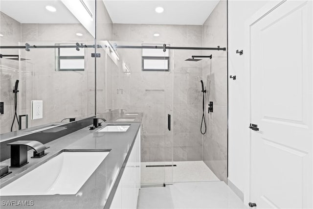 full bath with plenty of natural light, double vanity, a shower stall, and recessed lighting