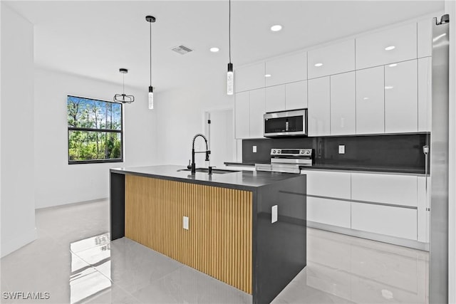 kitchen with stainless steel appliances, a sink, dark countertops, modern cabinets, and white cabinets