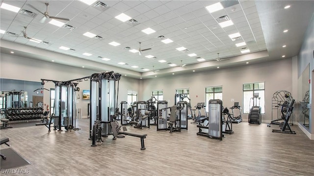 20669 Greenwich Pl, Estero, FL 33928 - gym featuring a towering ceiling, wood finished floors, a paneled ceiling, and baseboards