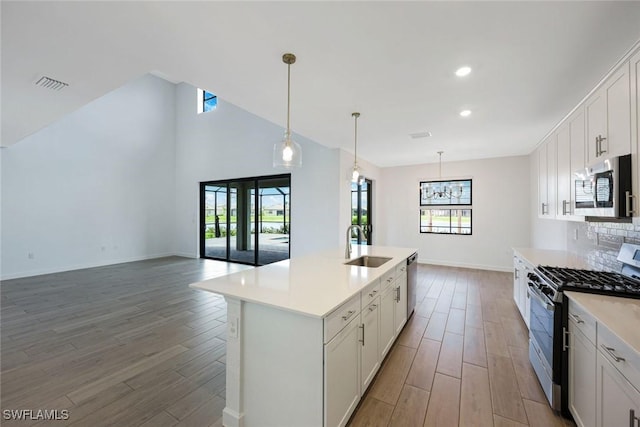 20669 Greenwich Pl, Estero, FL 33928 - kitchen featuring stainless steel appliances, light wood-style floors, light countertops, recessed lighting, and vaulted ceiling