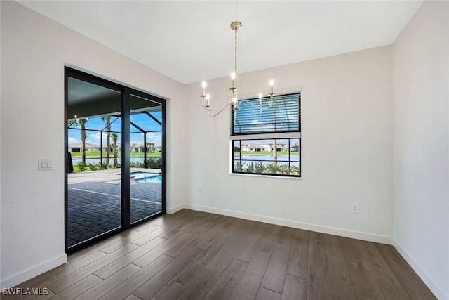 20669 Greenwich Pl, Estero, FL 33928 - spare room featuring wood finished floors and a chandelier