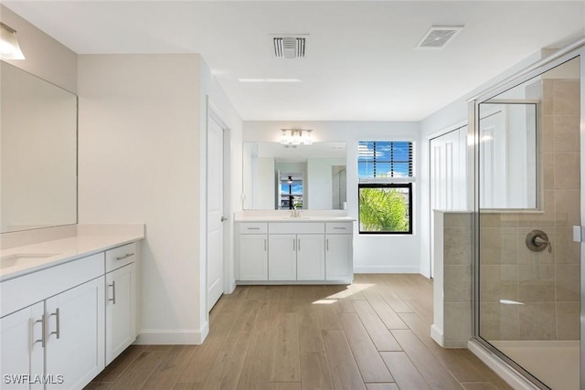 20669 Greenwich Pl, Estero, FL 33928 - full bathroom with two vanities, a stall shower, wood finished floors, and a chandelier