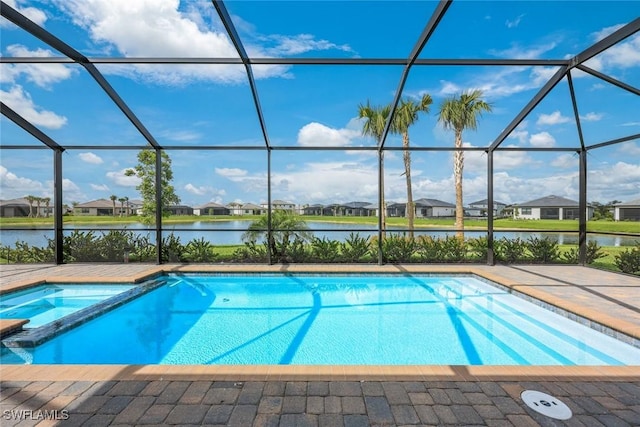 20669 Greenwich Pl, Estero, FL 33928 - view of swimming pool featuring glass enclosure, a water view, a pool with connected hot tub, and a residential view