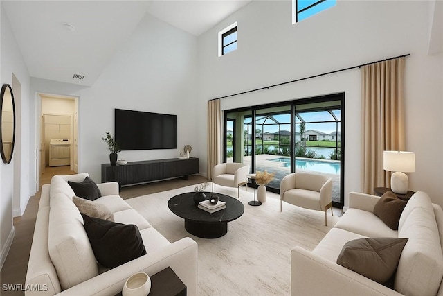 20669 Greenwich Pl, Estero, FL 33928 - living area with washer / clothes dryer, high vaulted ceiling, and wood finished floors