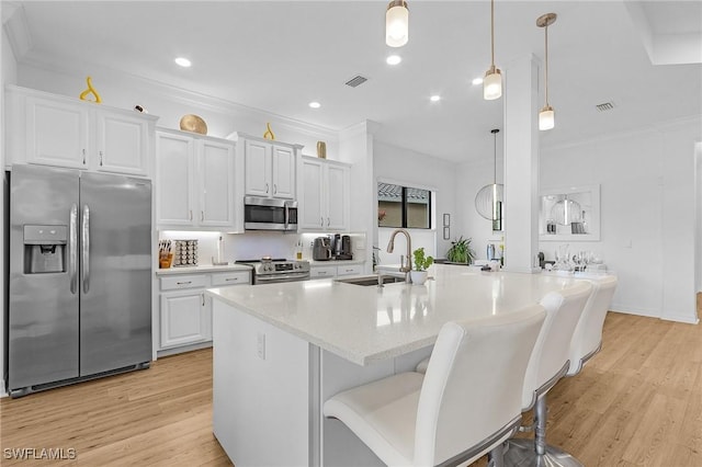 3813 Columbia Ct, Naples, FL 34119 - kitchen with stainless steel appliances, a sink, light wood finished floors, white cabinetry, and recessed lighting