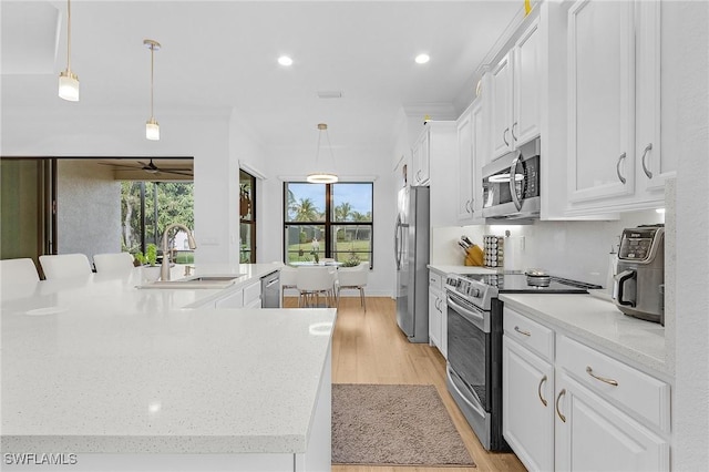 3813 Columbia Ct, Naples, FL 34119 - kitchen with stainless steel appliances, a sink, white cabinetry, healthy amount of natural light, and recessed lighting