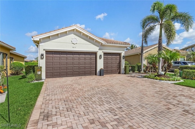 3813 Columbia Ct, Naples, FL 34119 - view of front facade featuring decorative driveway, stucco siding, a garage, and a front lawn