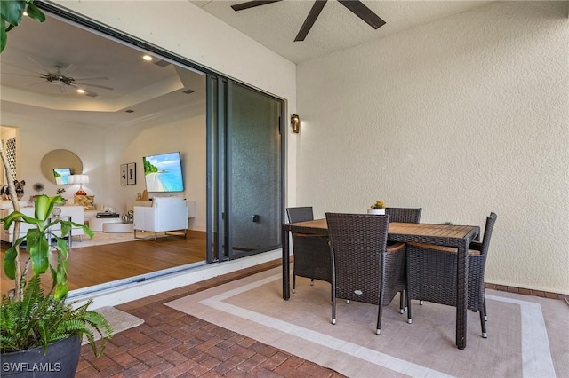3813 Columbia Ct, Naples, FL 34119 - dining room featuring a ceiling fan, a textured wall, brick patterned flooring, a tray ceiling, and baseboards