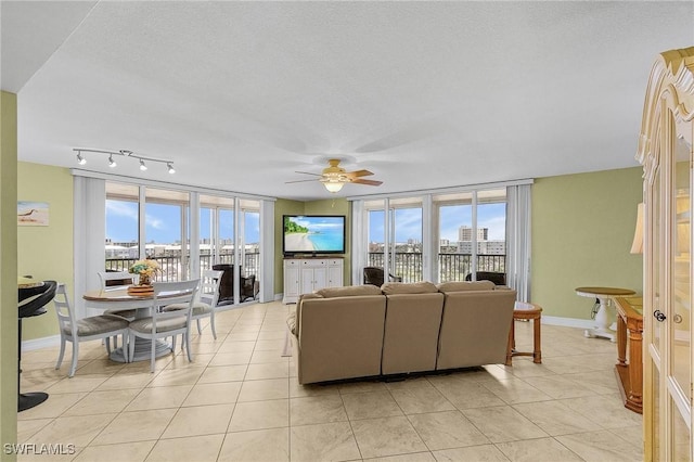 7150 Estero Blvd Unit 706, Fort Myers Beach, FL 33931 - living room featuring healthy amount of natural light, ceiling fan, light tile patterned flooring, baseboards, and a textured ceiling