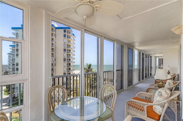 7150 Estero Blvd Unit 706, Fort Myers Beach, FL 33931 - sunroom featuring a textured wall, a water view, healthy amount of natural light, and carpet
