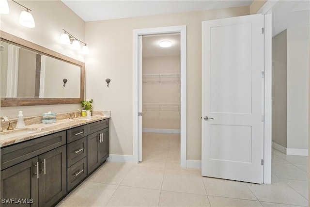2519 SW 15th Ave, Cape Coral, FL 33914 - full bathroom with double vanity, tile patterned flooring, baseboards, and a spacious closet