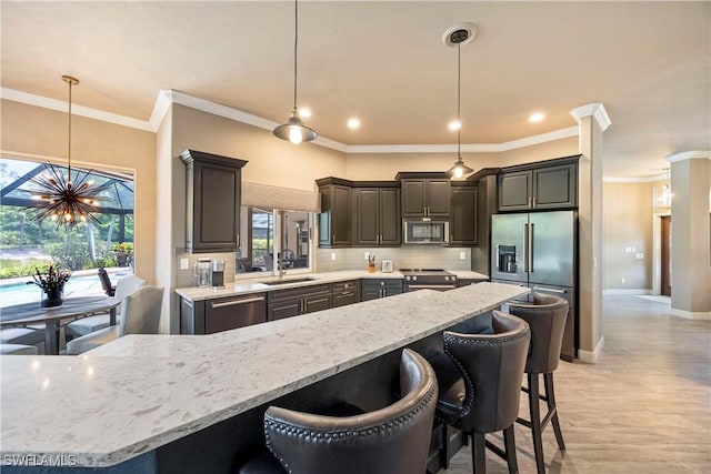 11041 Seminole Palm Way, Fort Myers, FL 33966 - kitchen featuring stainless steel appliances, a sink, tasteful backsplash, light stone counters, and crown molding